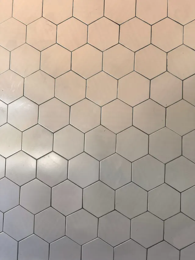 Finished feature wall in white hexagon tile with dark grout