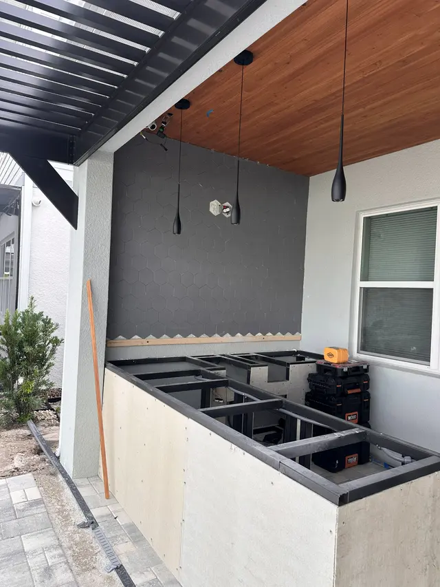 Outdoor kitchen frame going up, with the appliance openings blocked out