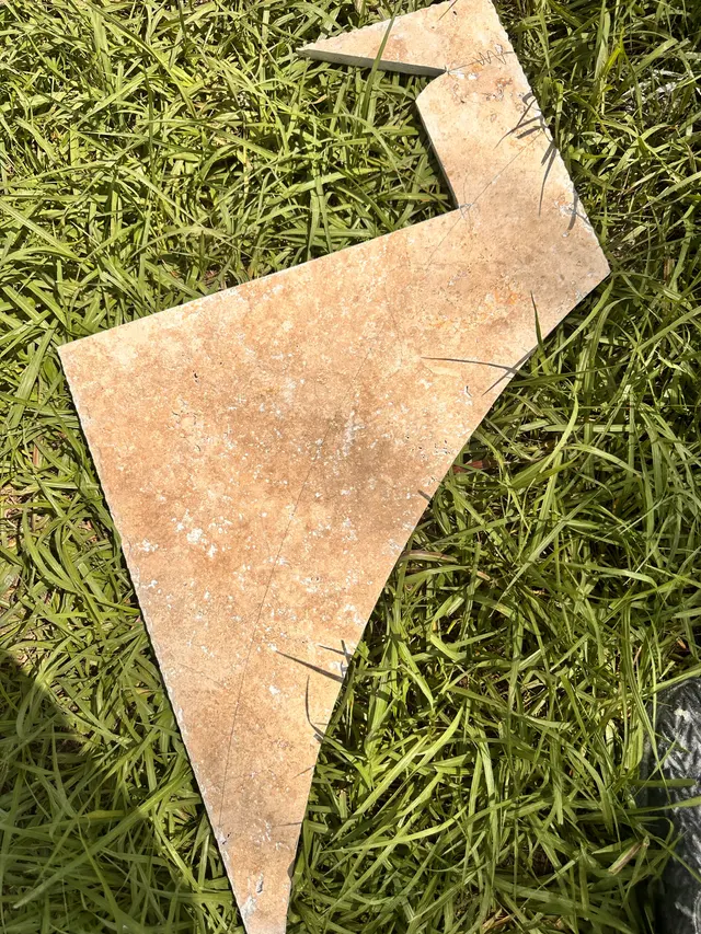 Cut travertine tile pieces laid out on the grass before installation
