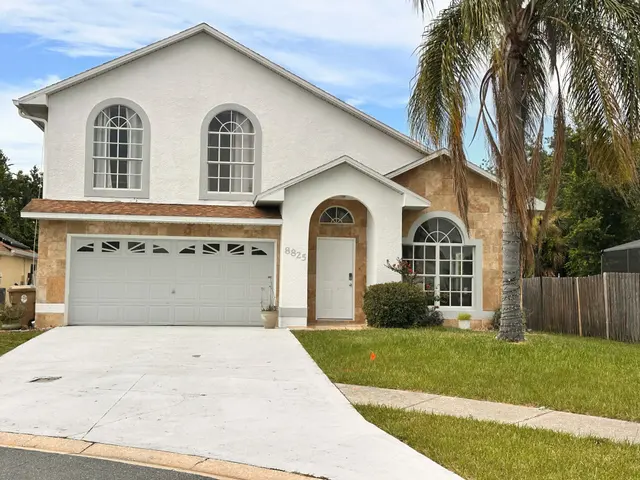 Front of a Central Florida home with a palm tree and a two car garage