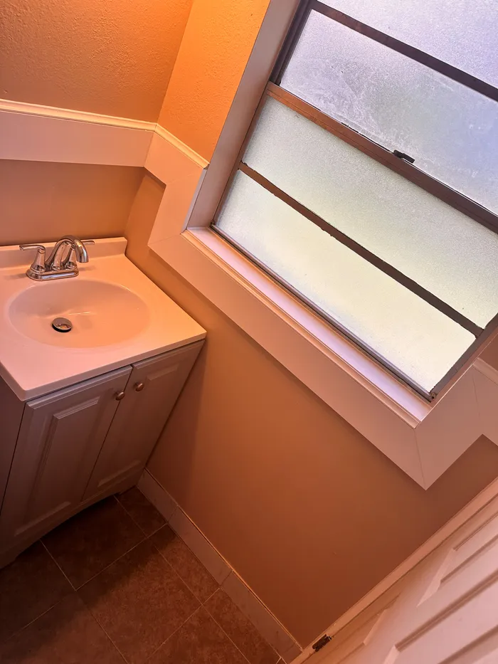 Dated bathroom before the remodel, with the original vanity and wall color
