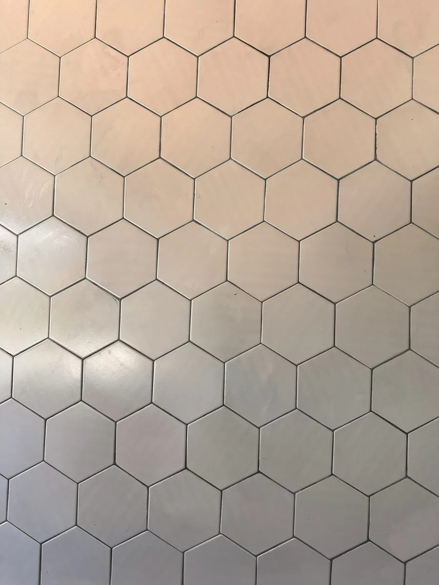Feature wall finished by B2B Construction in white hexagon tile with dark grout